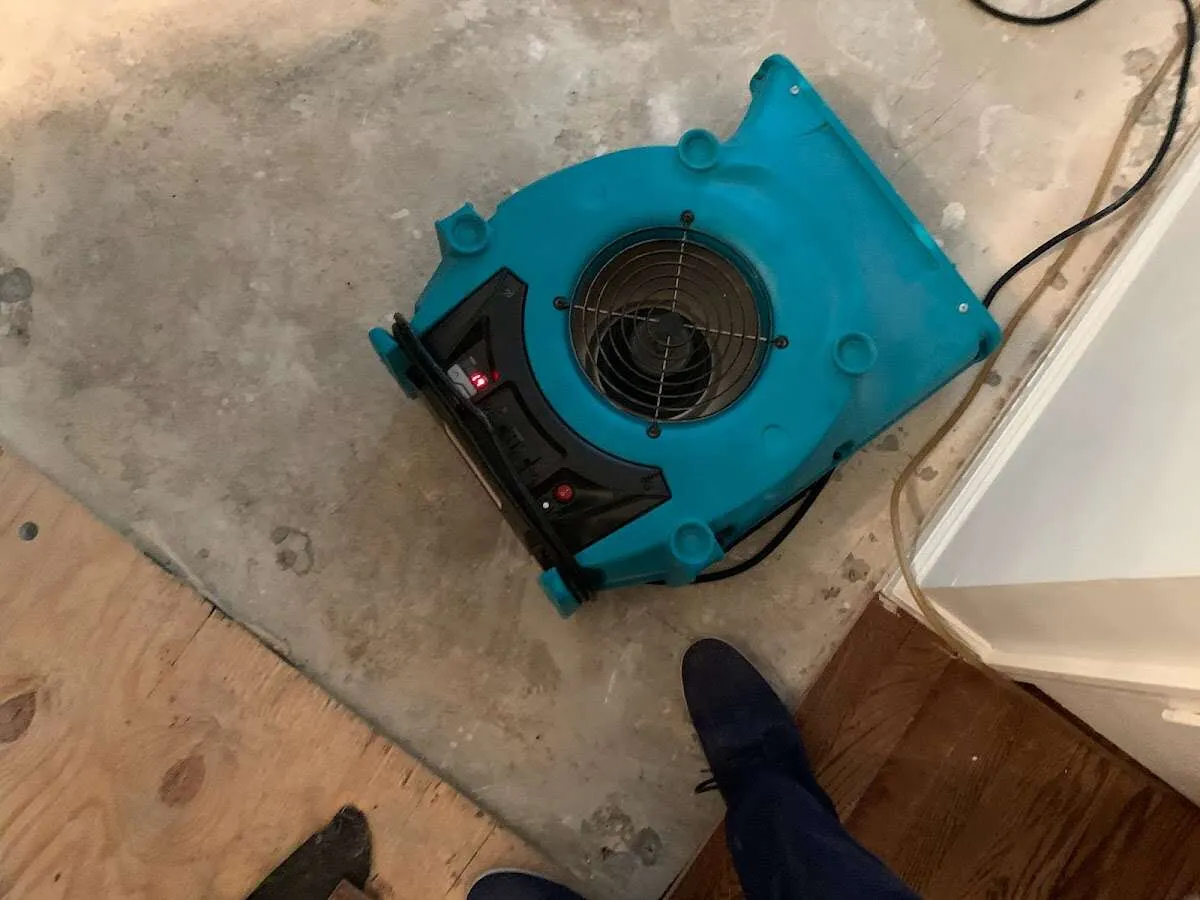 Air mover drying subfloor during Commercial Water Damage Restoration in Oak Grove